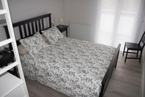 - une chambre dotée d'un lit avec un couvre-lit floral dans l'établissement IZASKUNena Home E-BI 1190, à Getxo