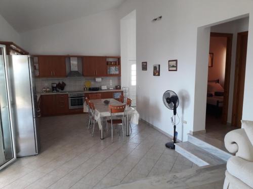 a kitchen and dining room with a table and a refrigerator at Ionian Balcony - Davgata in Dhavgáta