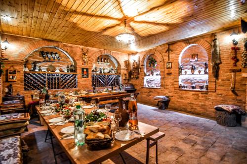 a dining room with wooden tables and wine bottles at apartamenti Laliashvilebi's wine cellar in Tbilisi City