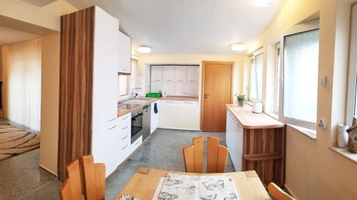 a kitchen with white cabinets and a wooden table at A Spacious 3 Bedroom Apartment in Bad Abbach/Regensburg in Bad Abbach