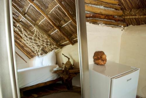 a bedroom with a bed and a refrigerator in a room at Serena Tulum - Adults Only in Tulum