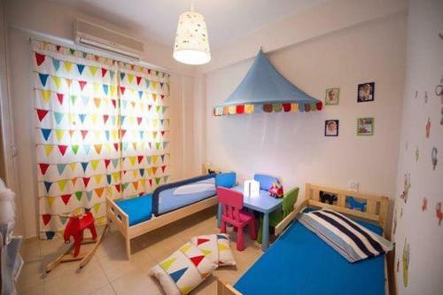 a childs room with a play area with two beds and a table at Seaside Family House in Nikiana