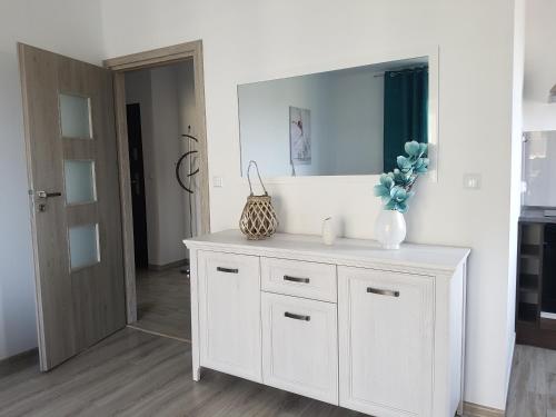スウプスクにあるNarutowicza Modern Apartment 2の鏡付きの部屋の白いドレッサー