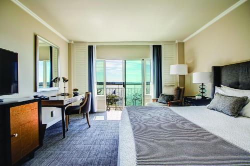 a hotel room with a bed and a desk with a television at The Woodmark Hotel & Still Spa on Lake Washington in Kirkland