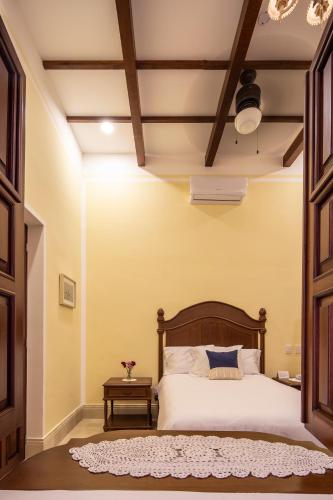a bedroom with a large bed and a table at Casa Tavera- Adults Only in Mérida