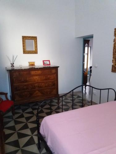a bedroom with a bed and a wooden dresser at Appartamento in palazzina storica / Oberdan Suites in Alberobello