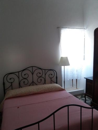 a bedroom with a bed with a red blanket and a window at Appartamento in palazzina storica / Oberdan Suites in Alberobello
