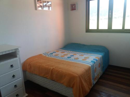 1 dormitorio pequeño con 1 cama, vestidor y ventana en Casa no Campeche, en Florianópolis