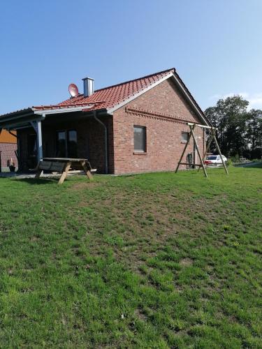 a brick house with a playground in front of it at Holunder Hüsken in Oberlangen
