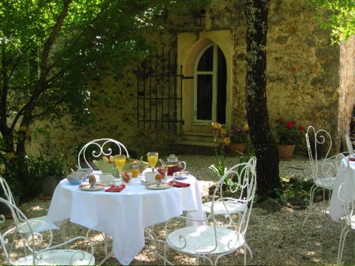 una mesa blanca con sillas y bebidas. en Le Mas Nomade, en Callian