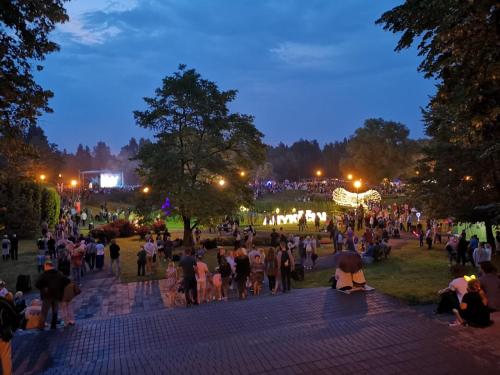 a crowd of people walking around a park at night at Kaimo turizmo sodyba Geras in Leliūnai