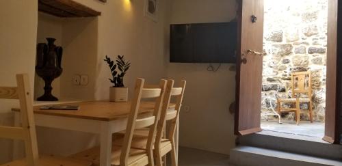 a dining room with a table and chairs and a television at Amaranti House n Art in Mandrakion