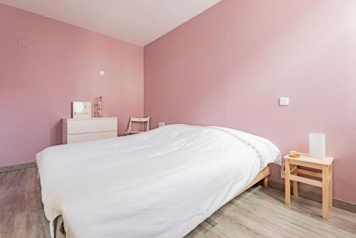 ランスにあるREIMS LA ROMAINEのピンクの壁のベッドルーム(ベッド1台、テーブル付)