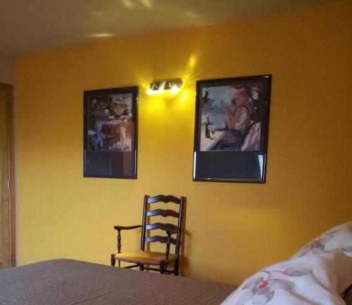 a bedroom with two pictures on the wall and a chair at B&B Herberg Boerenhol DE MOTE BVBA in Poperinge