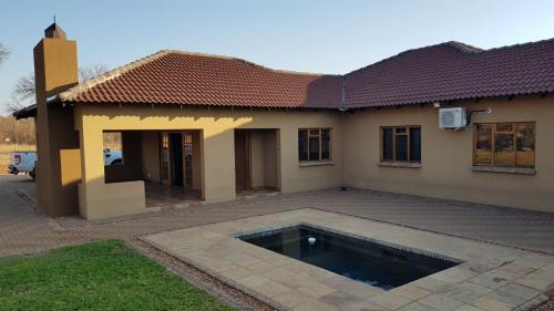 a house with a swimming pool in front of it at Hornbills Rest Country Home in Phalaborwa