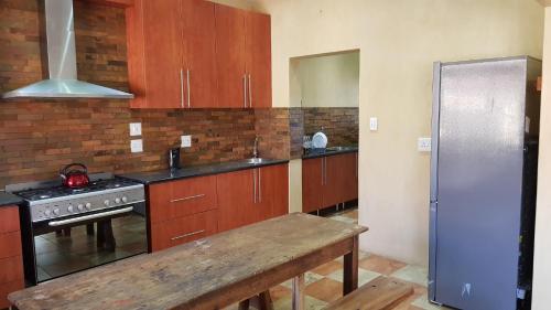 a kitchen with wooden cabinets and a stove and refrigerator at Hornbills Rest Country Home in Phalaborwa