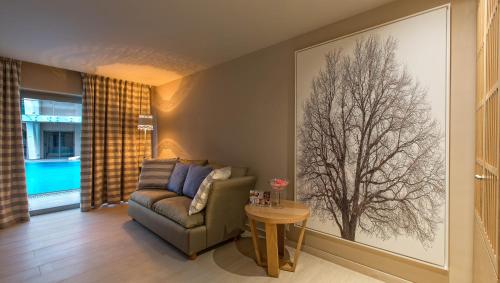 a living room with a couch and a tree on the wall at Eden Roc Resort - All Inclusive in Kallithea Rhodes