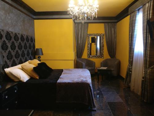 a bedroom with a bed and a chandelier at Julina Boutique Living in Mosta