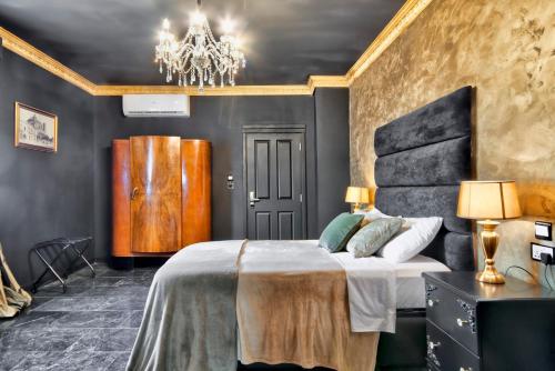 a bedroom with a large bed and a chandelier at Julina Boutique Living in Mosta