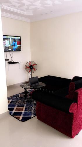 Résidence ESSOWE-SIM في داكار: غرفة معيشة مع أريكة وطاولة
