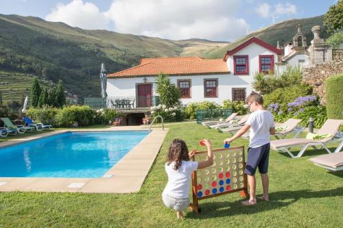 a boy and a girl playing with a xylophone by a pool at Casa do Monte - Douro in Baião