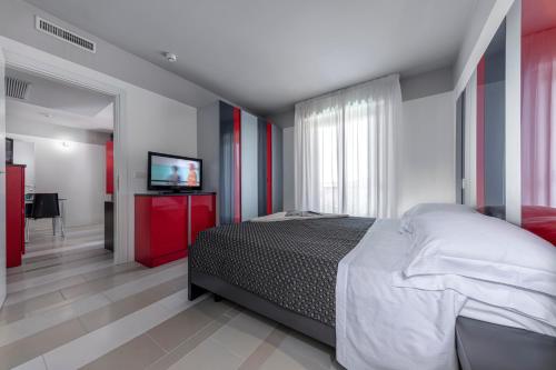 - une chambre avec un lit et une télévision à écran plat dans l'établissement Residence Altomare, à Riccione