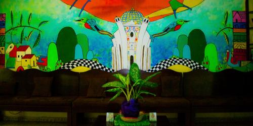 a wall with a painting of a tower with birds at Hotel Oasis in San Salvador