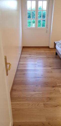 an empty room with a wooden floor and a window at Crown Roads in Le Faouët