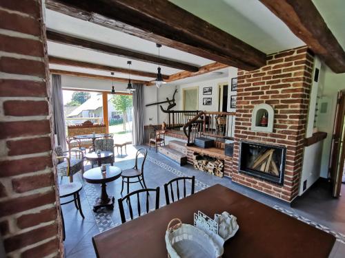 a living room with a brick fireplace and a table at Penzion Okamžik Stanovice in Nová Cerekev