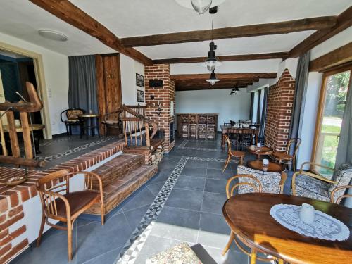 a living room with tables and chairs and a brick wall at Penzion Okamžik Stanovice in Nová Cerekev