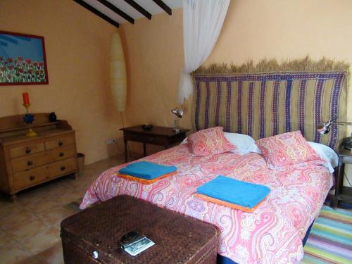 Un dormitorio con una cama con carpetas azules. en Encantadora Casa con piscina privada en el Risco de Agaete, en Agaete
