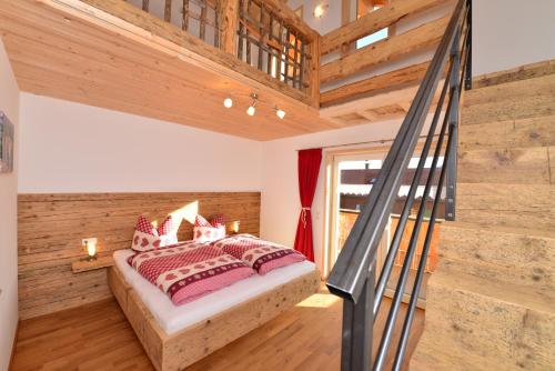 a bedroom with a bed in a room with wooden walls at Landhof Müller in Wertach