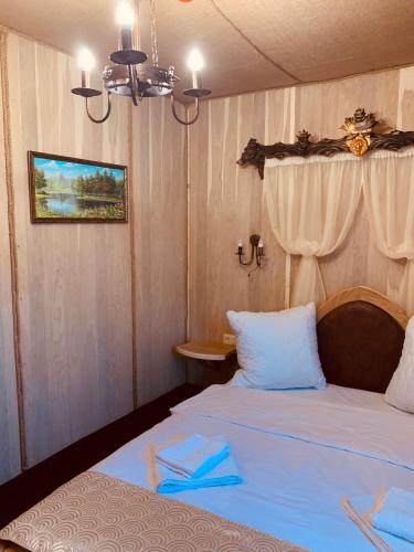 a bedroom with two beds with blue napkins on them at Готельно-ресторанний комплекс «Галицький замок» in Ternopilʼ