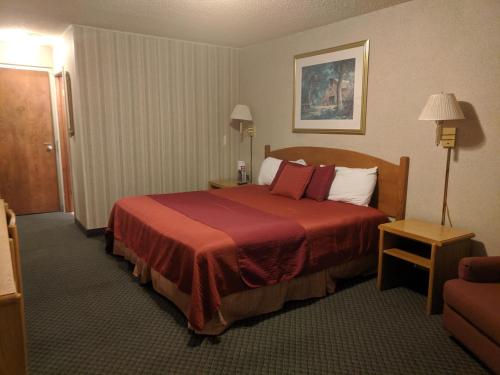 a hotel room with a bed with a red blanket at Red Carpet Motel - Knoxville in Knoxville