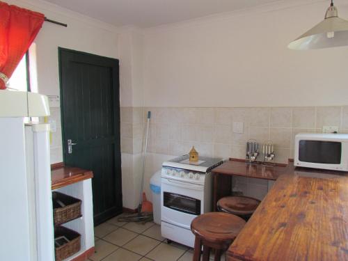 a kitchen with a white stove and a table at Pumula Guest Farm in Fouriesburg