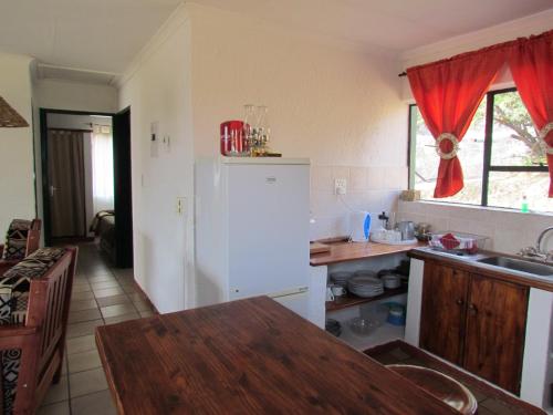 a kitchen with a white refrigerator and a table at Pumula Guest Farm in Fouriesburg