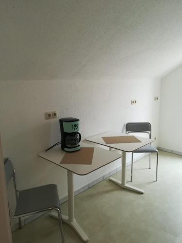 two tables in a room with a coffee maker on them at Kunstgasse 11, Wohnung 10 in Altenburg