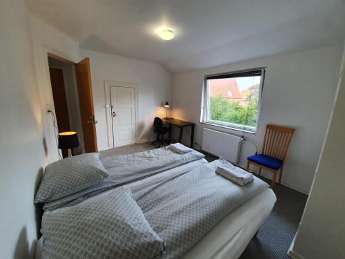 a bedroom with a large bed and a window at Struer Town Apartment in Struer
