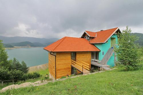 a house with an orange roof on top of a hill at Tara lake apartments in Jevtići