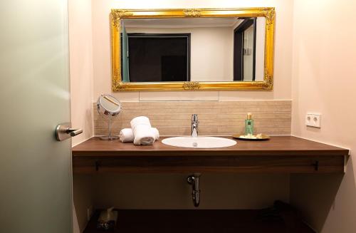 ein Bad mit einem Waschbecken und einem Spiegel in der Unterkunft Hotel Zuckerfabrik in Stuttgart
