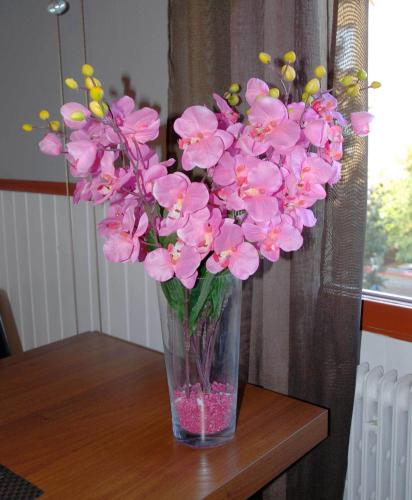 a vase filled with pink flowers on a table at Avesta Stadshotell in Avesta