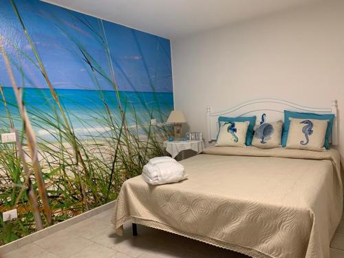 a bedroom with a bed and a mural of the beach at Villa Acquamarina semi detached villa with private pool and wifi in Torre delle Stelle