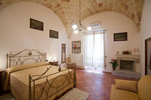a bedroom with a bed and a fireplace at Appartamenti Fusaro in Specchia