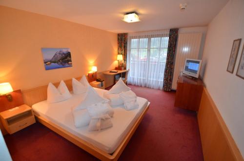 a hotel room with a bed with white pillows at Posthotel Rössle in Gaschurn
