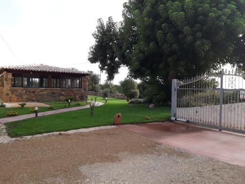 a house with a white gate and a yard at Agriturismo Quattro Mori in Porto Torres