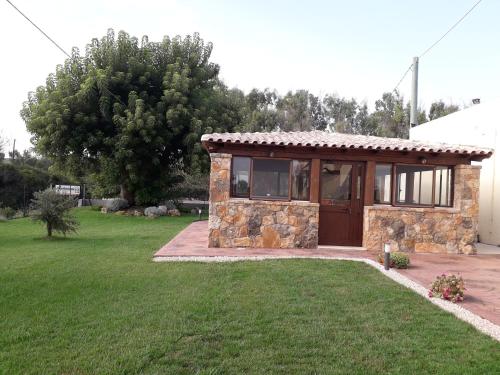 a small stone house with a grass yard at Agriturismo Quattro Mori in Porto Torres
