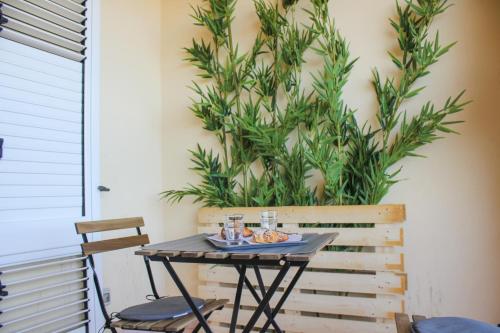a table and chairs in front of a plant at BELICE APPARTAMENT in Salemi