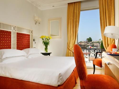 una camera con letto e balcone di FH55 Grand Hotel Palatino a Roma