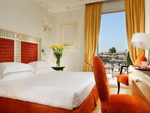 a hotel room with a bed and a balcony at FH55 Grand Hotel Palatino in Rome