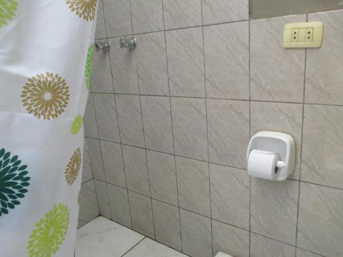 een badkamer met een toiletpapierdispenser aan de muur bij Wayqi Wasi in Pisac